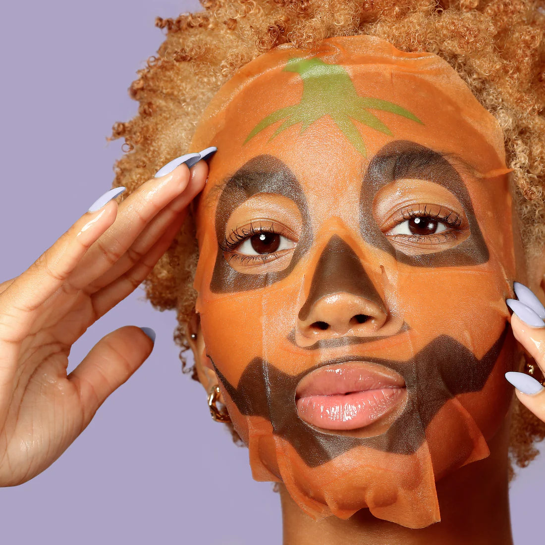 Halloween character face mask on skin with orange jack-o-lantern pattern