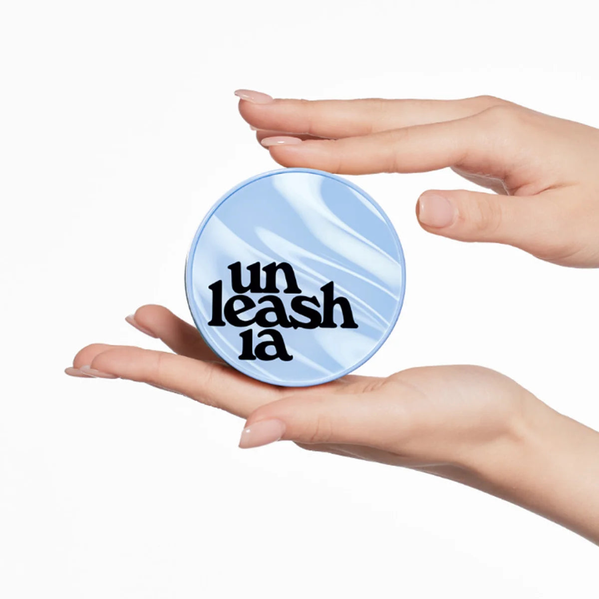 Blue round cushion compact with hands holding the lid
